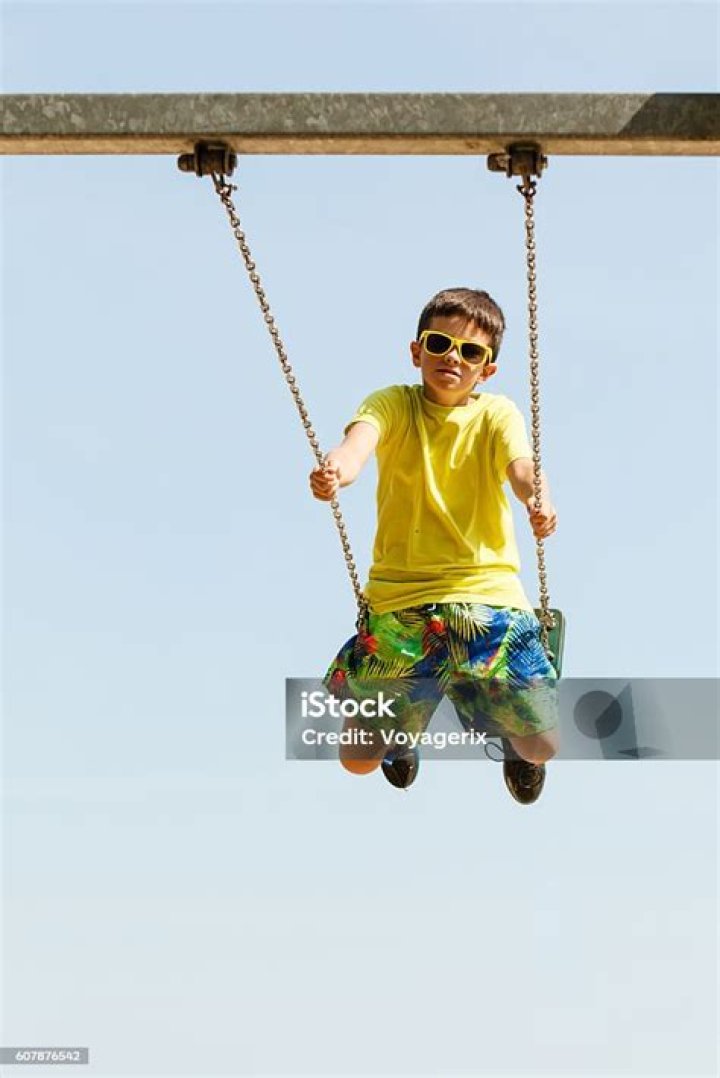 Boy Playing Swinging by Swingset. Stock Image Image of height