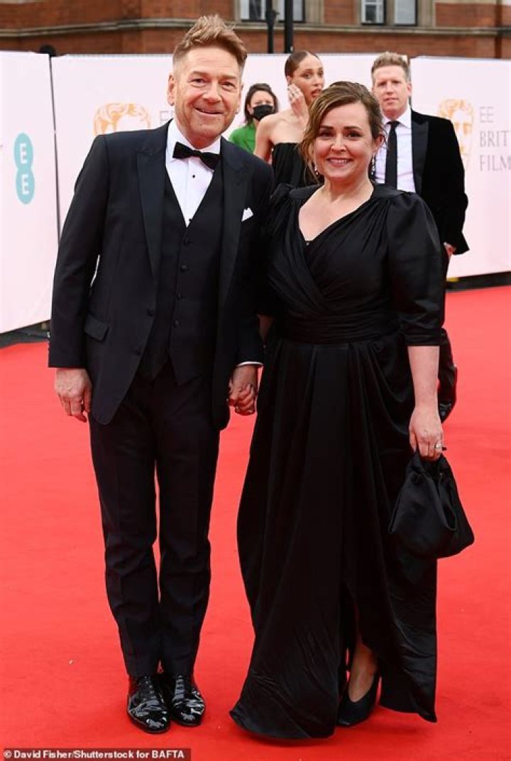 Branagh leads wife Lindsay Brunnock by the hand at LAX airport