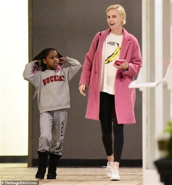 Charlize Theron models a pink coat over with her daughter August in Los