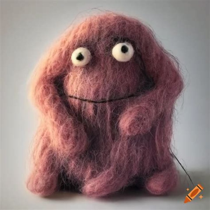 Felted wool monster with a sad expression