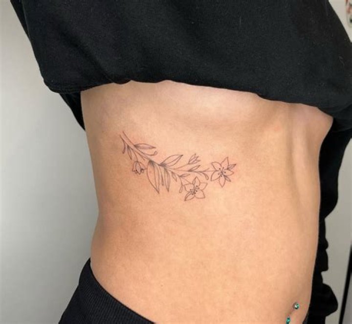 Floral rib tattoo Small Rib Tattoos, Flower Tattoo On Ribs, Side