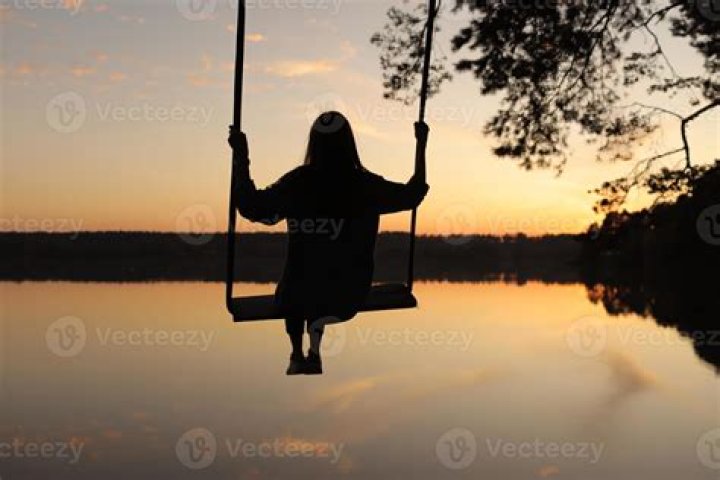 Girl swinging by lake Stock Photo Alamy