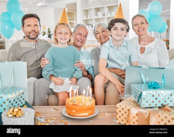 Happy family celebrating a birthday together at table Stock Photo Alamy