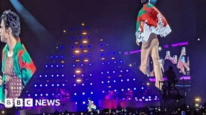 Harry Styles delights Cardiff crowd by donning Welsh flag BBC News