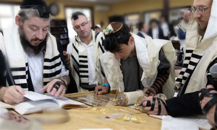 Jewish refugees and Mitzvah Day volunteers knit blankets for the