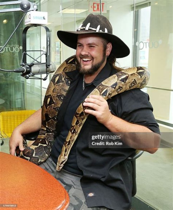 Jimmy Riffle of Animal Gator Boys holds a boa snake as he
