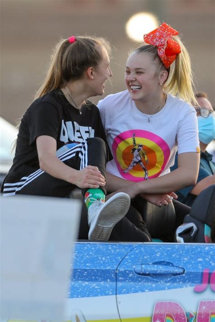 JoJo Siwa kisses girlfriend Kylie Prew as the couple hold hands and