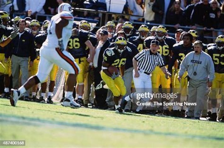 Julius Curry of the Michigan Wolverines leads the cheers as the team