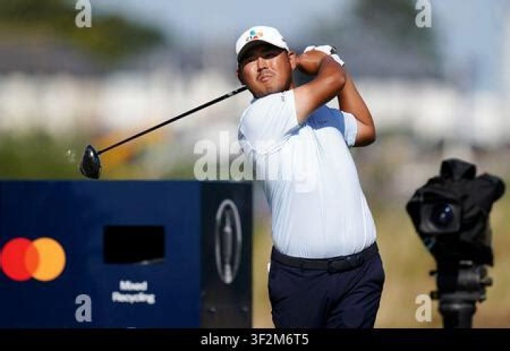 Si Woo Kim of South Korea and his caddie walk along the first hole