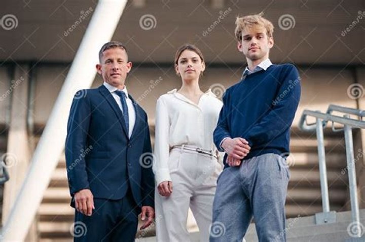 three people standing next to each other in front of a painting