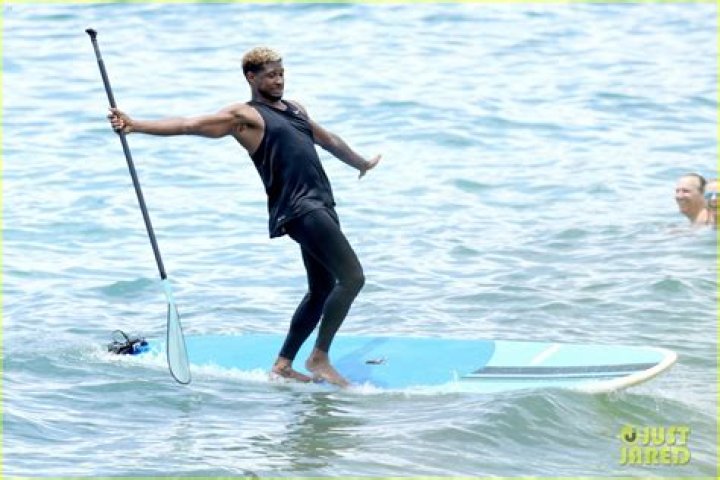 Usher Stays Clothed While Paddle Boarding, Goes Shirtless on the Beach
