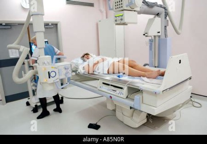 Woman having barium enema on table of Siemens Medical Solutions Axiom